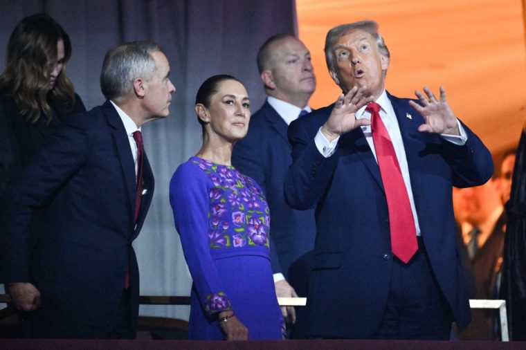 (FILES) (L/R) Canada's Prime Minister Mark Carney, Mexico's President Claudia Sheinbaum, and US President Donald Trump speak with each other during the draw for the 2026 FIFA Football World Cup taking place in the US, Canada and Mexico, at the Kennedy Center, in Washington, DC, on December 5, 2025. Mexican President Claudia Sheinbaum wore a purple, indigenous-embroidered dress at her first meeting with Donald Trump during the 2026 World Cup draw, a choice seen as symbolizing women's power. That week, The New York Times named her among the world's most stylish figures, highlighting her strategy of blending indigenous craftsmanship with modern elegance to send a political message. (Photo by Mandel NGAN / POOL / AFP via Getty Images)