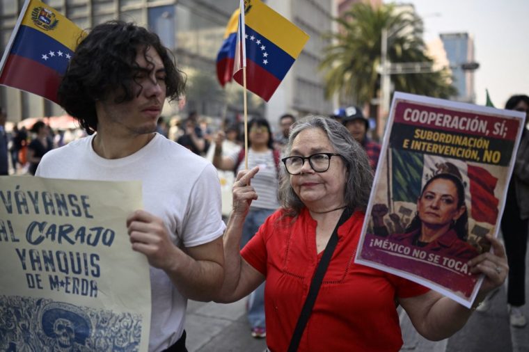 Demonstrators hold allusive signs during a march in Mexico City on January 10, 2026, in support of deposed Venezuelan president Nicolas Maduro and his wife Cilia Flores and against a possible US intervention in Mexico. Mexican President Claudia Sheinbaum said her government wanted closer security coordination with the US and repeatedly opposed any foreign military intervention after Donald Trump threatened to launch ground attacks against drug cartels. (Photo by Alfredo ESTRELLA / AFP via Getty Images)